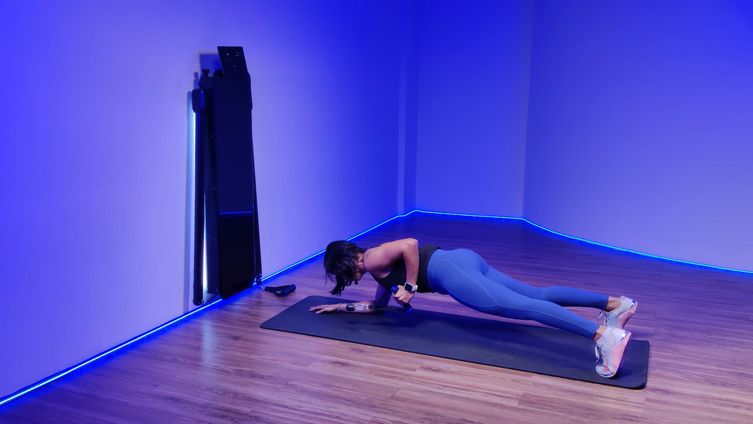 A woman performing an elbow plank single arm cable row exercise with a cable machine