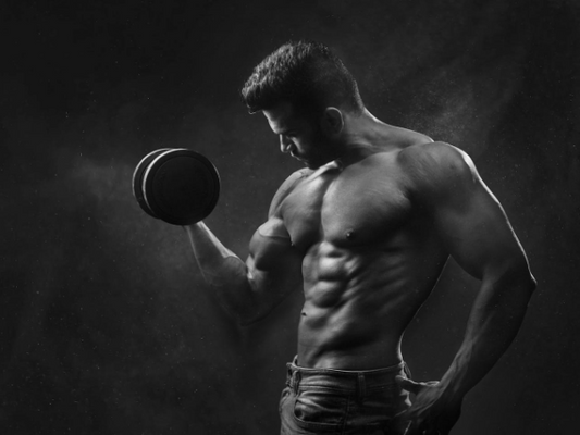 Muscular man lifting a dumbbell, showcasing the power of pre-workout supplements for muscle growth.