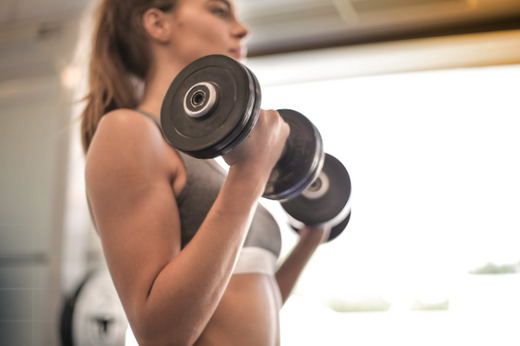 Woman lifting dumbbells, exploring muscle gain without protein