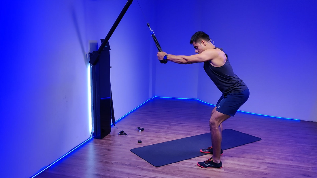 Man performing Rope Straight Arm Pulls exercise in a gym with blue lighting