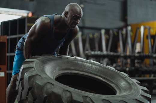 Man lifting a tire during 1 hour weight training to burn calories