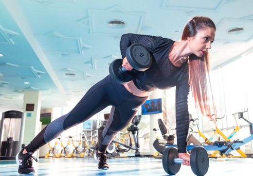 Woman performing strength training with dumbbells in gym