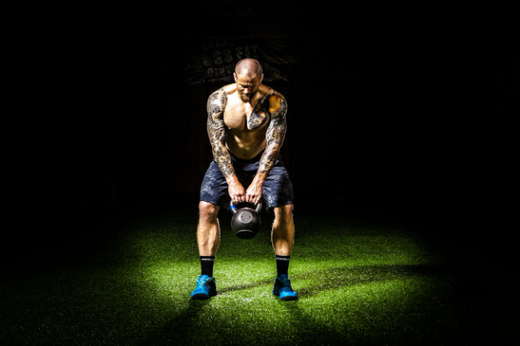 An athlete performing weight training with kettlebell