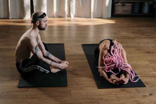 Two individuals practicing functional strength training exercises on yoga mats